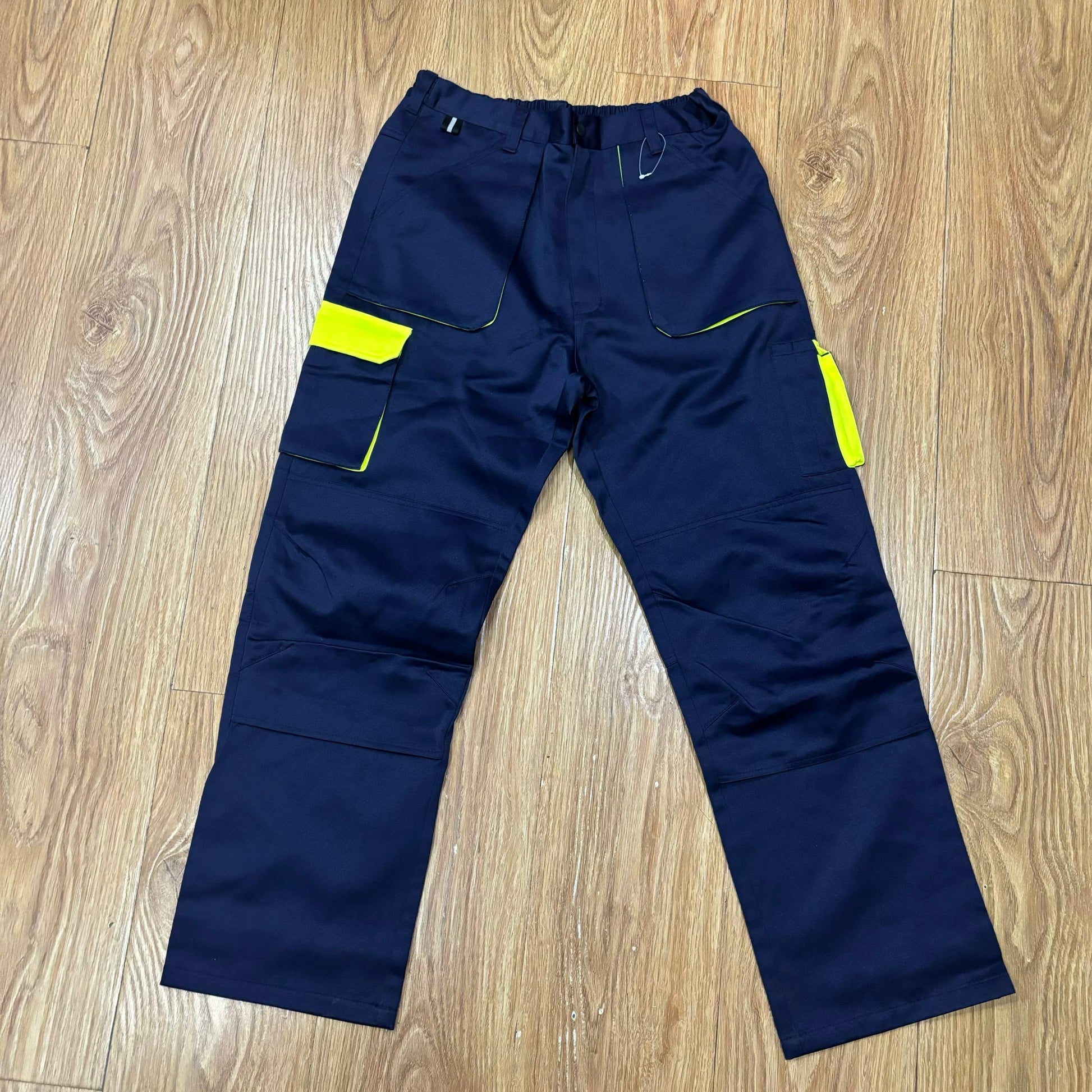 Navy blue work pants with neon yellow accents and reflective safety strips for construction