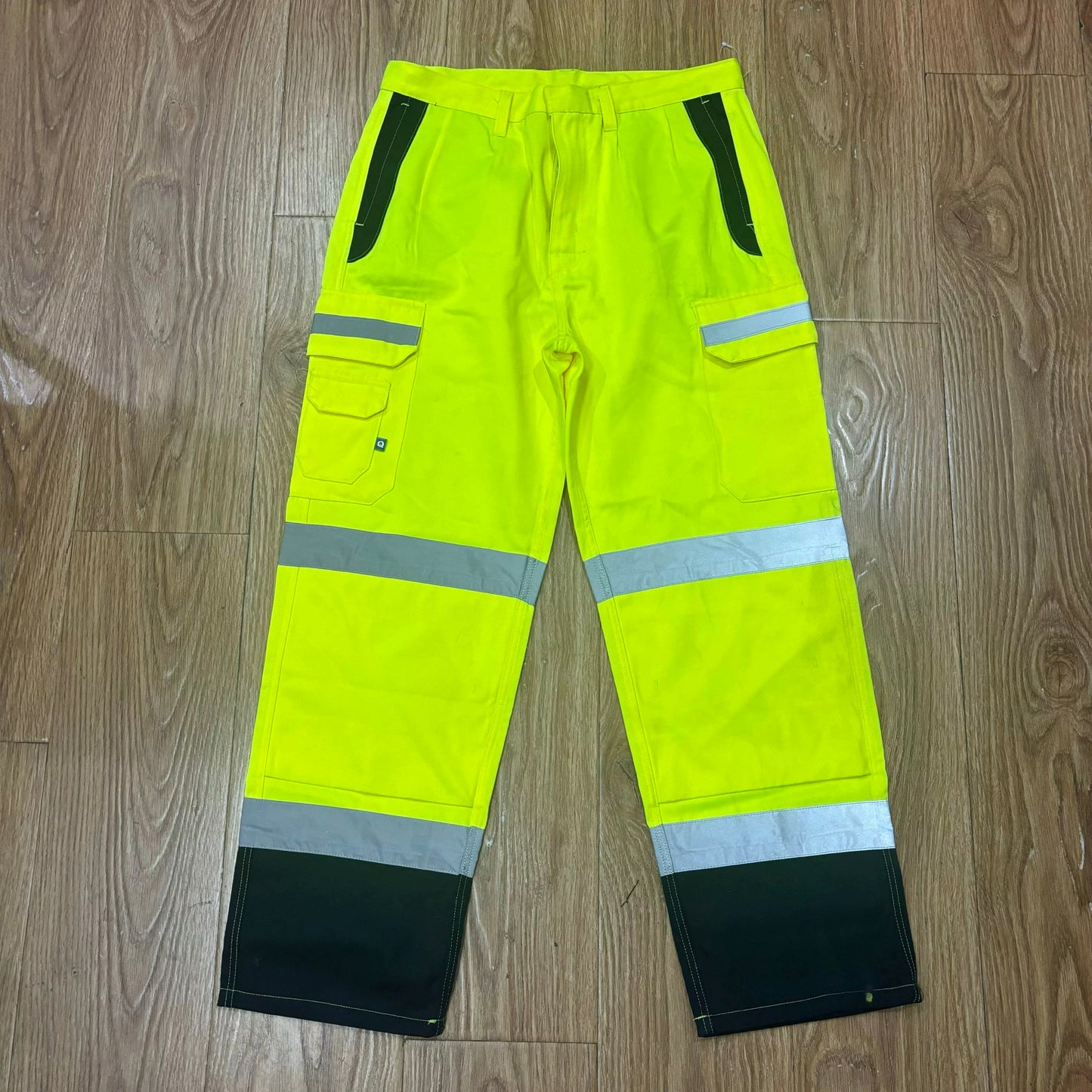 Fluorescent yellow high visibility work pants with reflective strips and multi-pocket design for construction safety